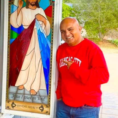 A community member beside a Vetrata della Divina Misericordia