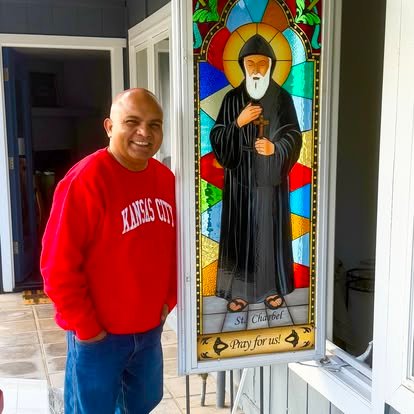 A community member beside a stained-glass image of San Giovanni Eudes